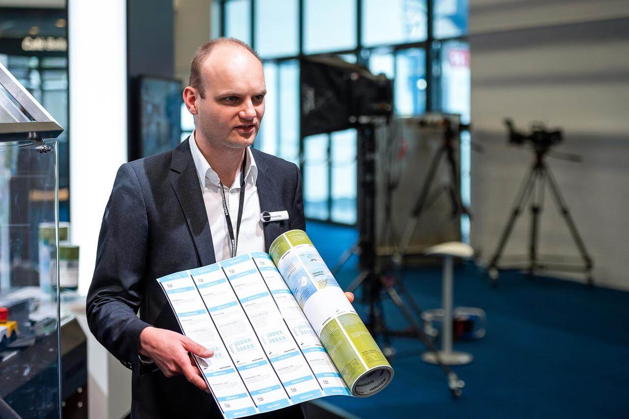 A Bizerba employee presenting the CleanCut® Linerless Labels (© Bizerba) 